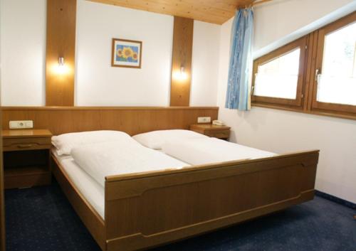 ein Schlafzimmer mit einem großen Bett und einem Fenster in der Unterkunft Haus Anton Schranz in Sankt Anton am Arlberg