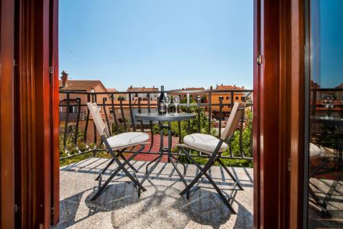 un tavolo e sedie su un balcone con vista di Apartments Vanda a Rovigno (Rovinj)