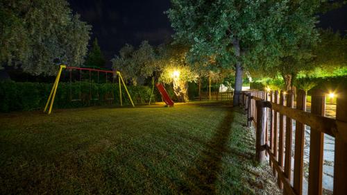 un parque de noche con columpios en Aneton, en Chrysi Ammoudia