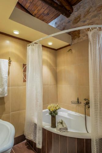 a bathroom with a bath tub and a sink at Private Stone villa-Pool and Maountain view in Karés