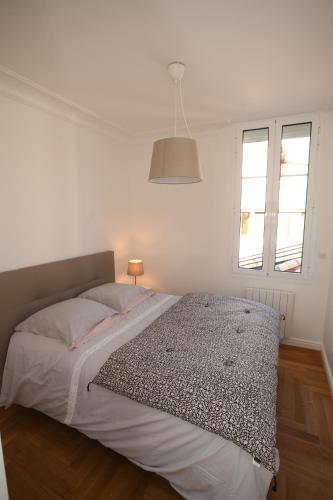 une chambre blanche avec un lit et deux fenêtres dans l'établissement Libourne Hyper Centre à deux pas de Saint Emilion, à Libourne