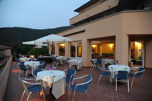 a restaurant with white tables and chairs and umbrellas at Hotel Residence Isola Verde in Marciana Marina