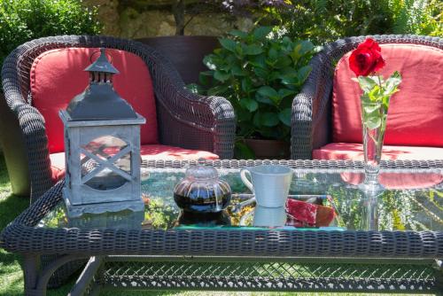 a wicker chair with a glass coffee table with a glass table at Hotel Casa del Marqués in Santillana del Mar