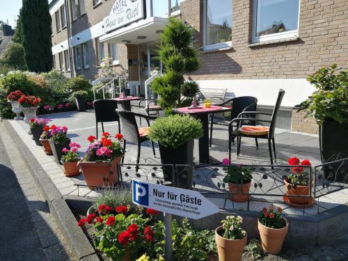 a sign in front of a cafe with flowers at Hotel Haus am Rieth in Nettetal