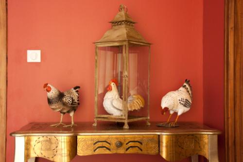 three chickens standing on a table with a lantern at Domaine de Janis & Spa in Le Vigan