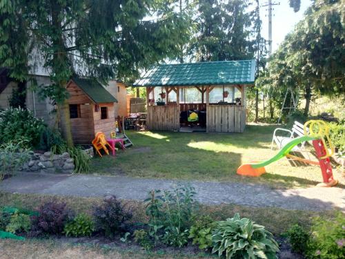 a backyard with a play house and a playground at Cichy Zakątek Junoszyno in Junoszyno