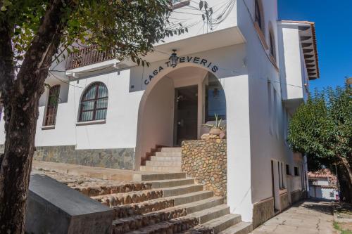 a white building with stairs in front of it at Casa Treveris - Non profit Hostel in Sucre