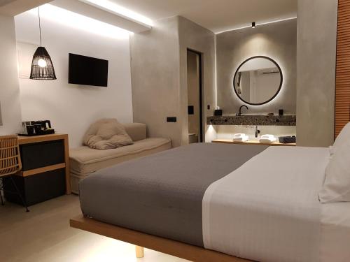a bedroom with a large bed and a mirror at Avra Mykonos in Tourlos