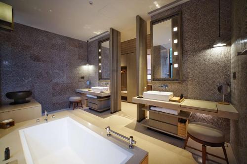 a bathroom with a large tub and two sinks at Yangshuo Sugar House in Yangshuo