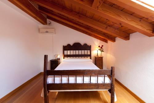 a bedroom with a bed in a room with wooden ceilings at Apartamentos Ea Astei in Ea