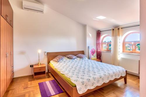um quarto com uma cama e duas janelas em Villa Valentina em Premantura
