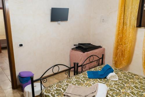 a bedroom with a bed and a tv on the wall at Agriturismo Biologico Sant'Andrea in Castellaneta Marina