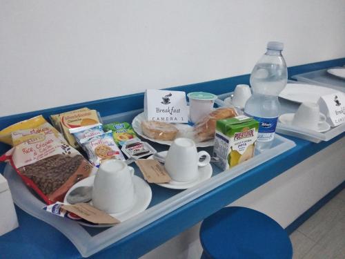 a tray with food and drinks and a bottle of water at ControVento Rooms in Margherita di Savoia