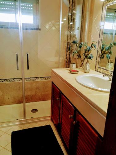 a bathroom with a shower and a sink at Apartamento Moura - Praia D’El Rey Golf, Surf & Beach Resort in Casal da Lagoa Seca