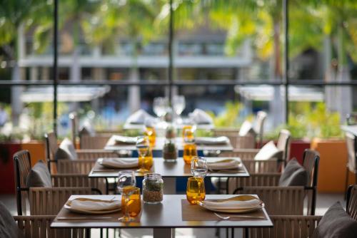 a group of tables in a restaurant with glasses and napkins at Catalonia Royal La Romana Adults Only - All Inclusive in Bayahibe