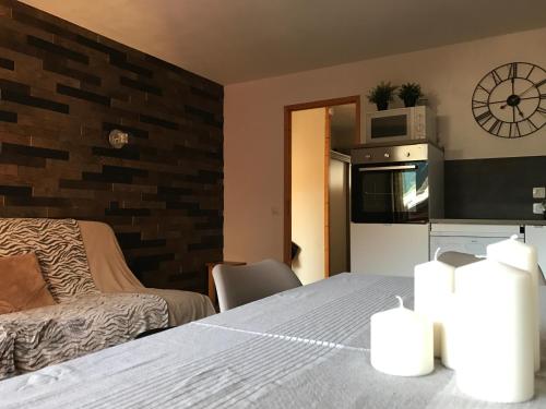 Il comprend une chambre avec un lit et une cuisine équipée d'un four micro-ondes. dans l'établissement VAUJANYLOCATIONS - La Fare Apt 12, à Vaujany