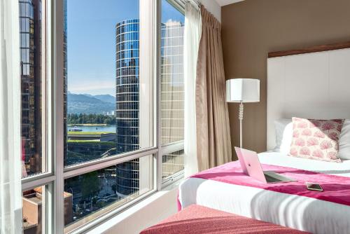 Postel nebo postele na pokoji v ubytování Auberge Vancouver Hotel