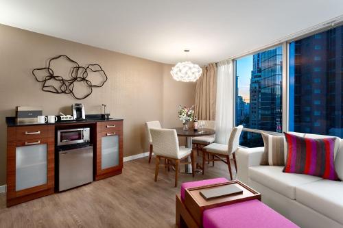 a living room filled with furniture and a tv at Auberge Vancouver Hotel in Vancouver