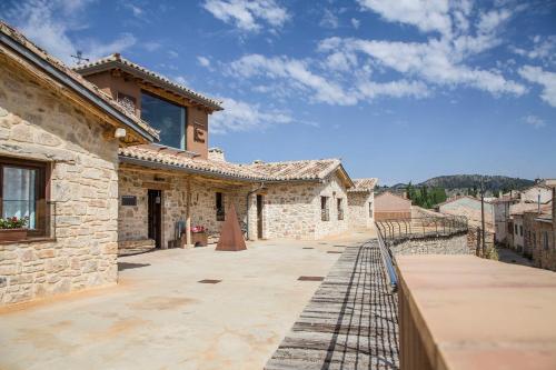 ein Steinhaus mit einem Zaun auf einer Terrasse in der Unterkunft Apartamentos Rurales de la Sexma del Sabinar in Corduente