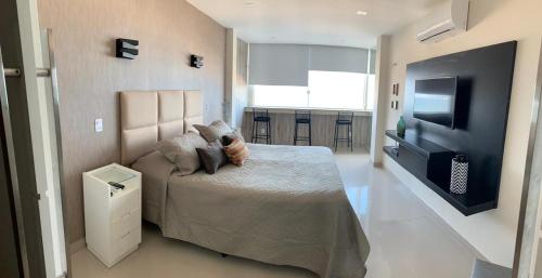 1 dormitorio con 1 cama y TV de pantalla plana en Studio Atlântica II en Río de Janeiro