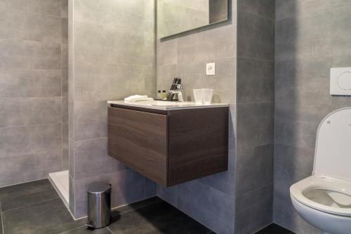 een badkamer met een wastafel en een toilet bij Hotel Huron in Mol
