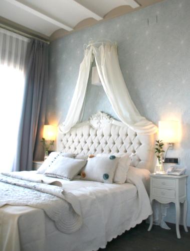 a bedroom with a white bed with a canopy at Hotel Castillo de Alquézar in Alquézar