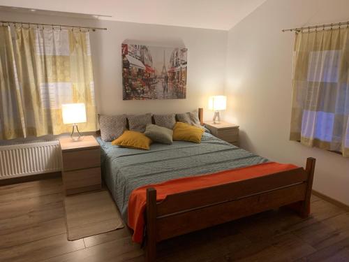 a bedroom with a bed with two lamps on tables at Apartamenty Podwarszawskie in Stara Wieś