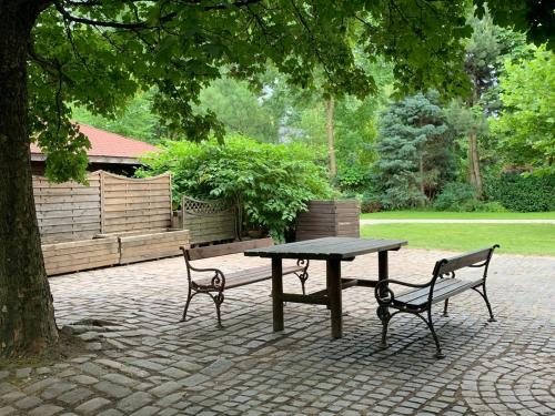 a picnic table and two benches in a park at Apartamenty Podwarszawskie in Stara Wieś