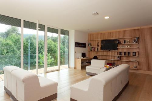 a living room with two white couches and a television at Apartamentos Ea Astei in Ea
