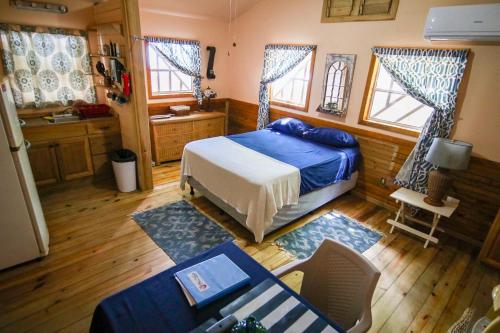 a bedroom with a bed and a table and chairs at Blue Island Divers Casita Azul in Sandy Bay