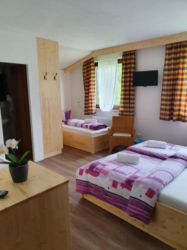 a bedroom with two beds and a living room at Pension INGE in Hinterstoder