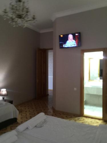 a room with a tv on the wall and a bed at HOTEL COMFORT in Kutaisi