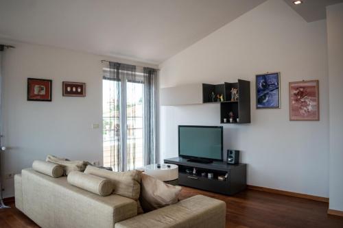 a living room with a couch and a flat screen tv at House Mia in Ližnjan