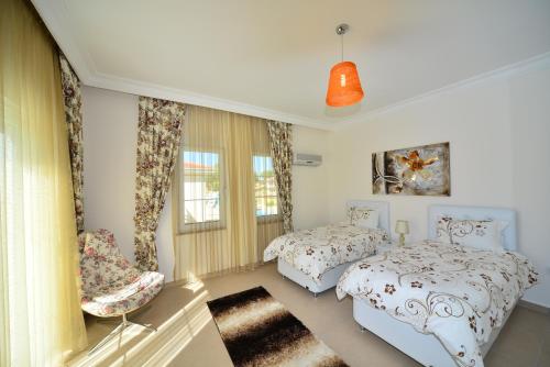 a bedroom with two beds and a chair at Ottoman Village in Alanya