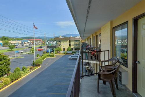 a balcony with a chair and a view of a street at Vacation Lodge in Pigeon Forge