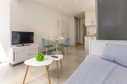 a living room with a couch and a tv and tables at Luxury apartments Nikolina Sea&City view in Makarska