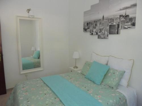 a bedroom with a bed and a mirror at Silence of the Birds in Olhão