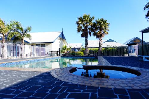 a swimming pool with a fountain in the middle at Torquay Tropicana Motel in Torquay