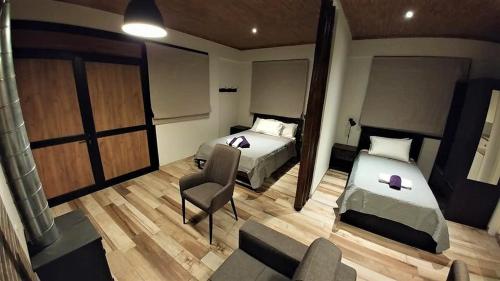 een hotelkamer met 2 bedden en een bank bij Perneia Rooms in Askas