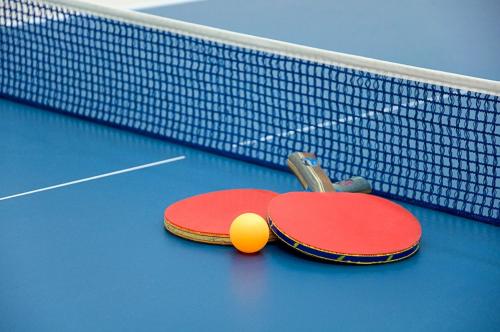 two tennis rackets and a ball on a tennis court at Torquay Tropicana Motel in Torquay
