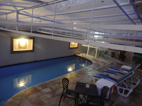 an overhead view of a pool with chairs and tables at Hotel Costa Balena-Piscina Aquecida Coberta in Guarujá