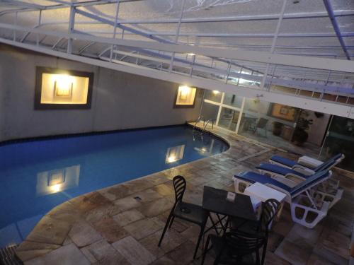 an overhead view of a swimming pool with chairs and tables at Hotel Costa Balena-Piscina Aquecida Coberta in Guarujá