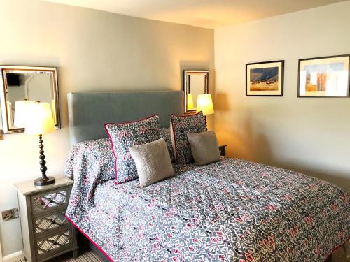a bedroom with a bed and two lamps and a mirror at The Red Lion Hotel in Oakford