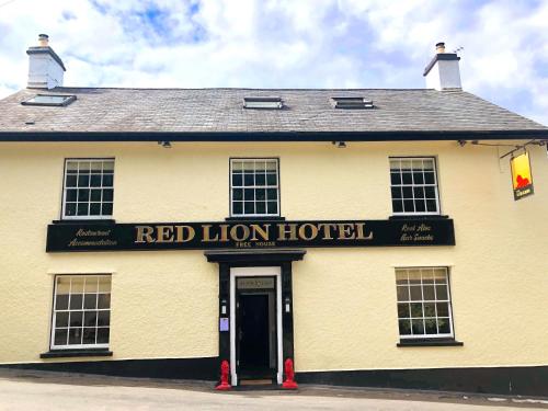 a yellow building with a red lion hotel sign on it at The Red Lion Hotel in Oakford