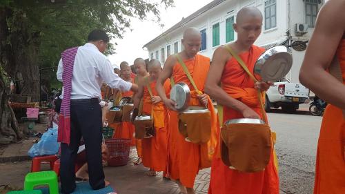 a group of people in orange robes playing drums at Y Not Laos Hostel in Luang Prabang