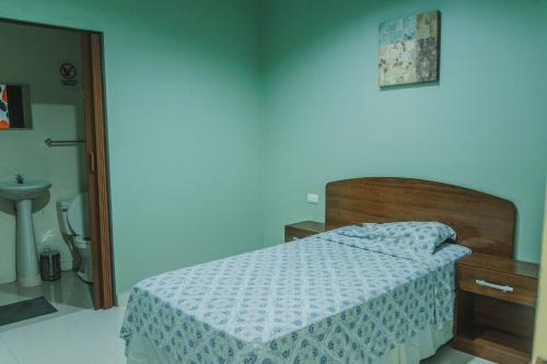 a bedroom with a bed and a bathroom with a sink at Hotel Casa Blanca in León