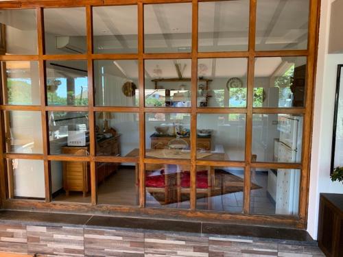 - une grande fenêtre en verre dans une chambre avec une table dans l'établissement b&b Casa di Antonio_Etna Vacanze, à Trecastagni