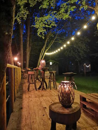 a patio with tables and lights at night at Riverland in Gornji Zvečaj