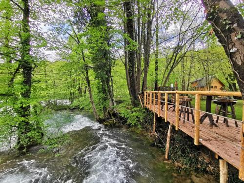 a bridge over a river next to a wooden bridge at Riverland in Gornji Zvečaj