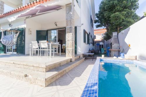 a villa with a swimming pool and a house at Magnólia Beach House - Cascais in Cascais